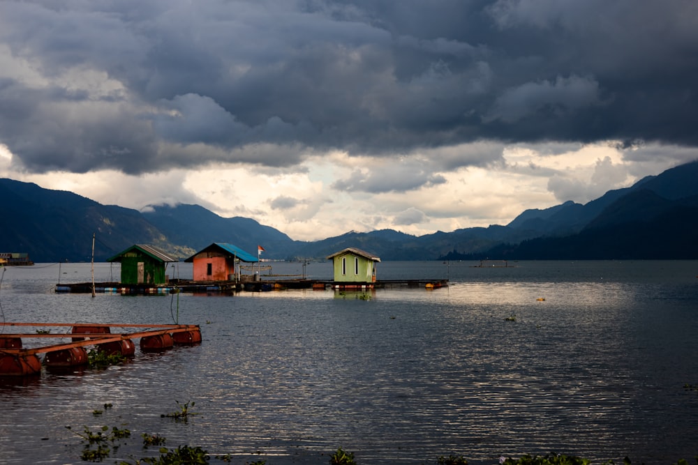 a body of water surrounded by mountains under a cloudy sky