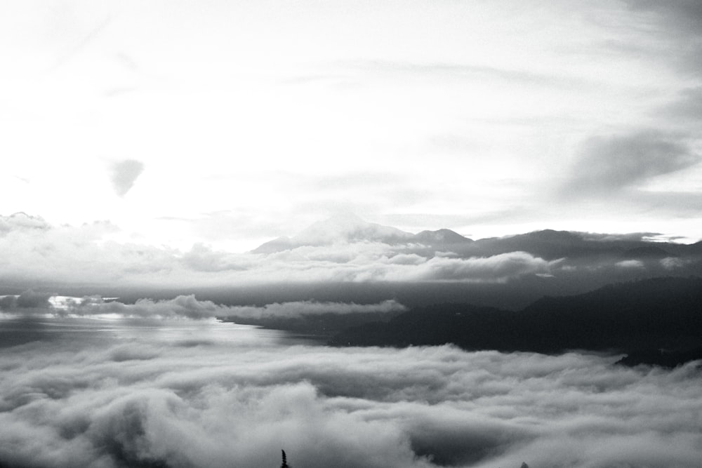 a black and white photo of clouds and mountains