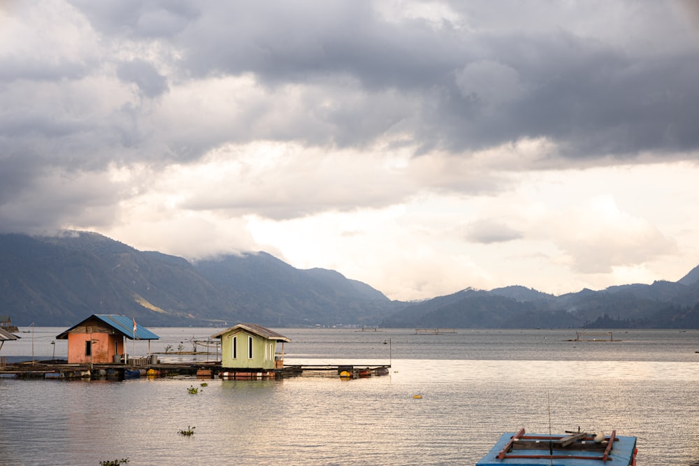 a boat floating on top of a lake under a cloudy sky