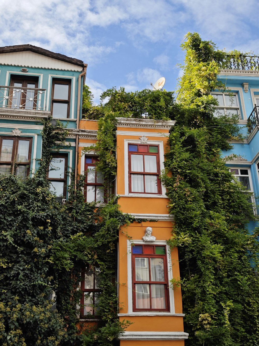 a tall building with many windows and plants growing on it