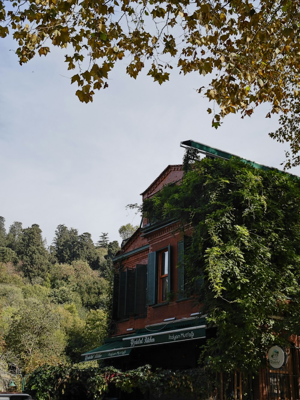 a red building with green shutters and a green awning