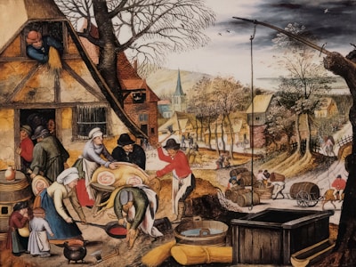 A bustling village scene featuring people engaged in various activities such as preparing food, carrying barrels, and working outside their homes. The village has rustic houses with thatched roofs, and vibrant trees line the path running through the settlement. In the foreground, several figures are preparing a large pig for cooking, while children and other adults observe and assist.