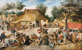 A lively village scene depicts a gathering of people engaging in various activities around a thatched-roof house. The atmosphere is festive, with groups of individuals eating, drinking, and socializing. Children and dogs are scattered throughout the scene, adding to the dynamic environment. Trees and additional cottages are visible in the background, suggesting a rural setting.
