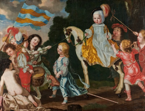A group of children are depicted in a playful scene with one child on a horse wearing a yellow and white outfit, surrounded by others wearing colorful clothing. One child is playing a drum while another is holding a large striped flag. The scene has elements of theatrical costuming, with feathers and bright fabrics. The background includes a lush, dark green foliage.