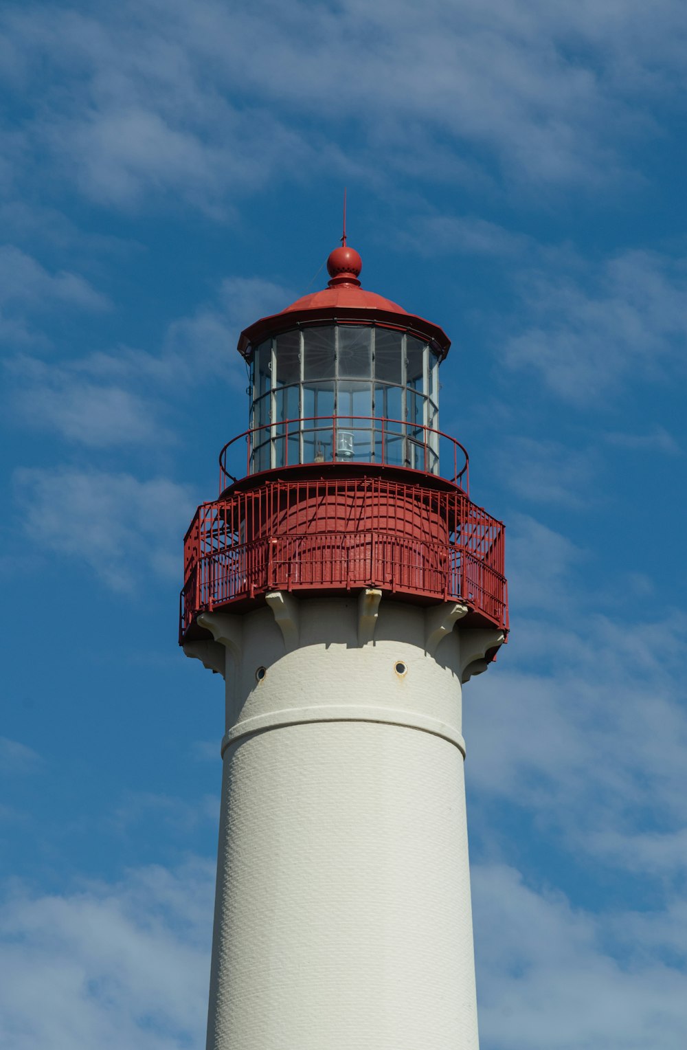 a red and white lighthouse against a blue sky