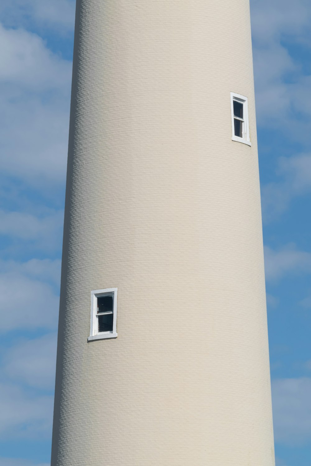 a white lighthouse with two windows on the side of it