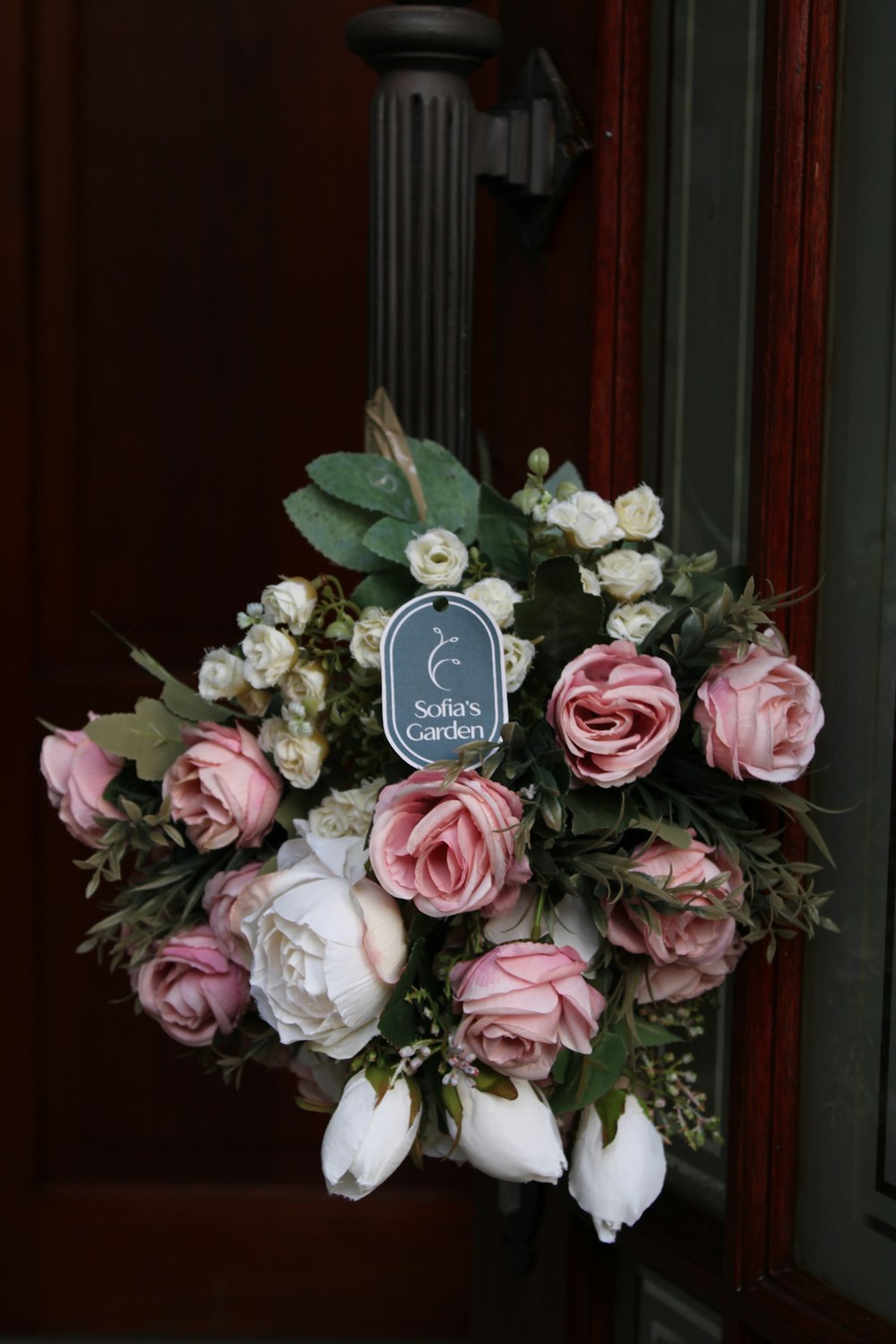 a bouquet of pink and white flowers sitting in front of a door