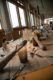 A beautifully set dining table in a hotel restaurant with elegant tableware.