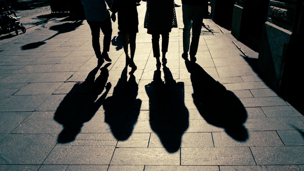 a group of people walking down a sidewalk