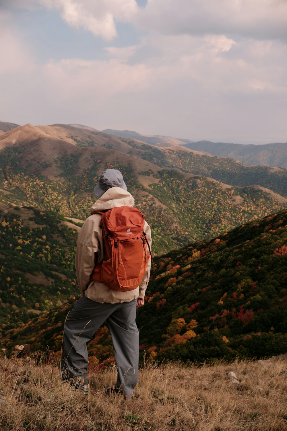 um homem com uma mochila em pé no topo de uma colina