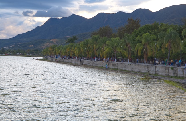 Two walkers chatting with locals along the scenic shores of Lake Geneva during the Caritour event.