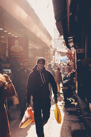 A vibrant street scene featuring a model wearing a bold graphic hoodie from nameless faceless.