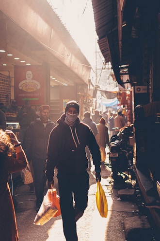 A vibrant street scene featuring a model wearing a bold graphic hoodie from nameless faceless.
