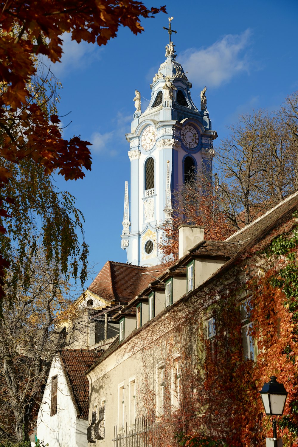 une haute tour d’horloge blanche surplombant une ville