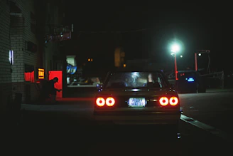 a car parked on the side of the road at night