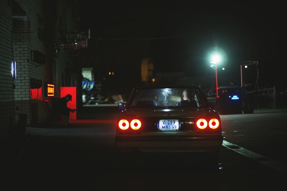 une voiture garée sur le bord de la route la nuit