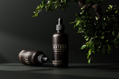 a bottle of hair oil next to a potted plant