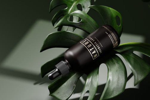 A dark bottle labeled 'NATURE' rests on a large green monstera leaf, with a dropper cap. The scene has a smooth, natural aesthetic complemented by soft lighting and shadows.