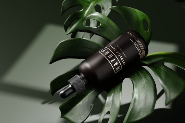 Artisanal glass bottle of natural oil resting on a wooden surface with tropical leaves in the background.