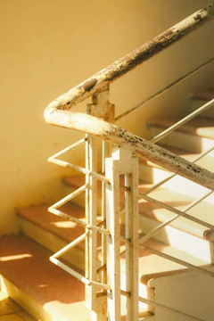 A sturdy grab bar installed along a staircase wall with warm natural light.