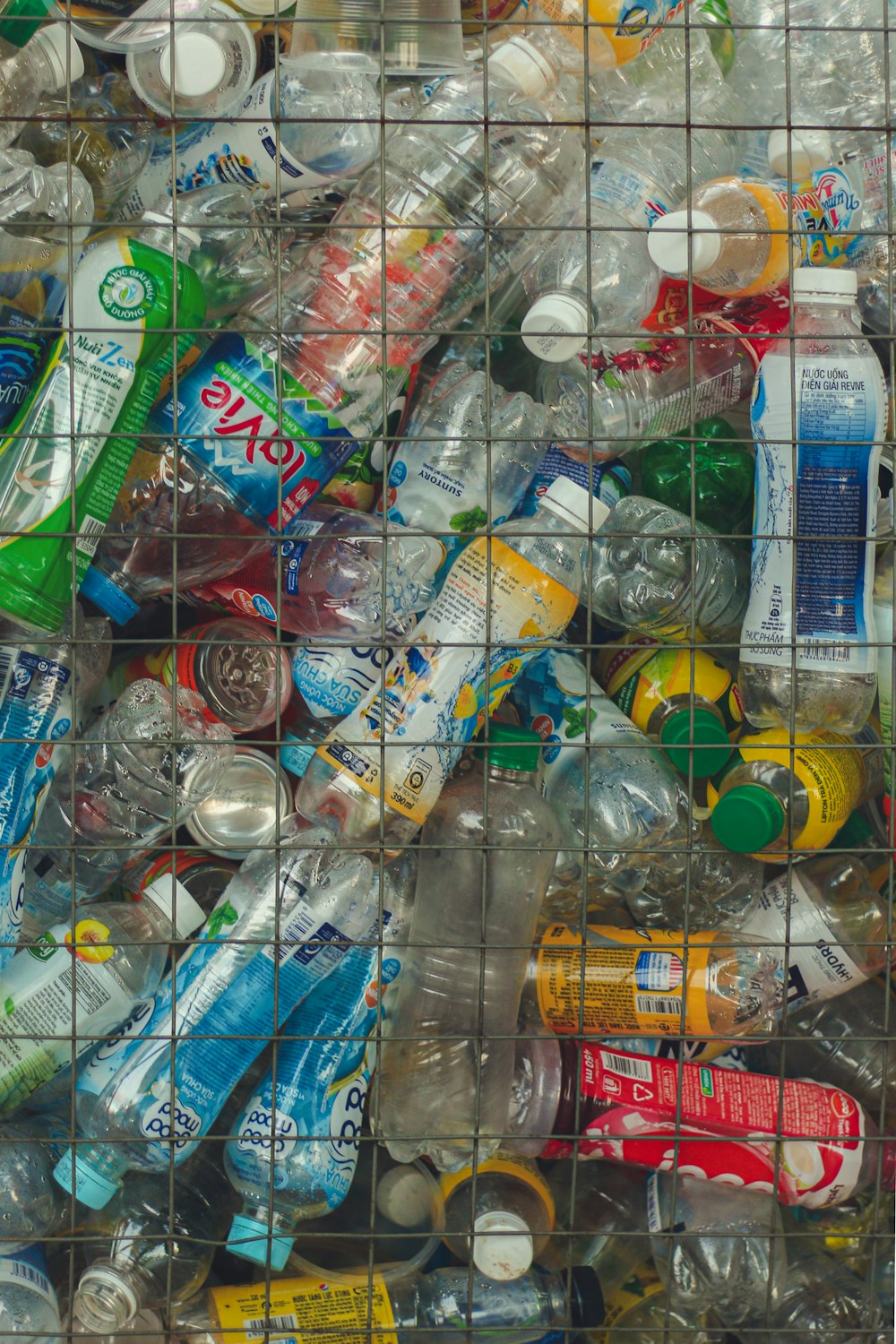 una pila de botellas y latas de plástico en una jaula