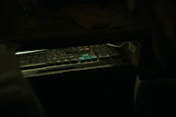 A tense scene of a hacker’s hands typing rapidly on a holographic keyboard.