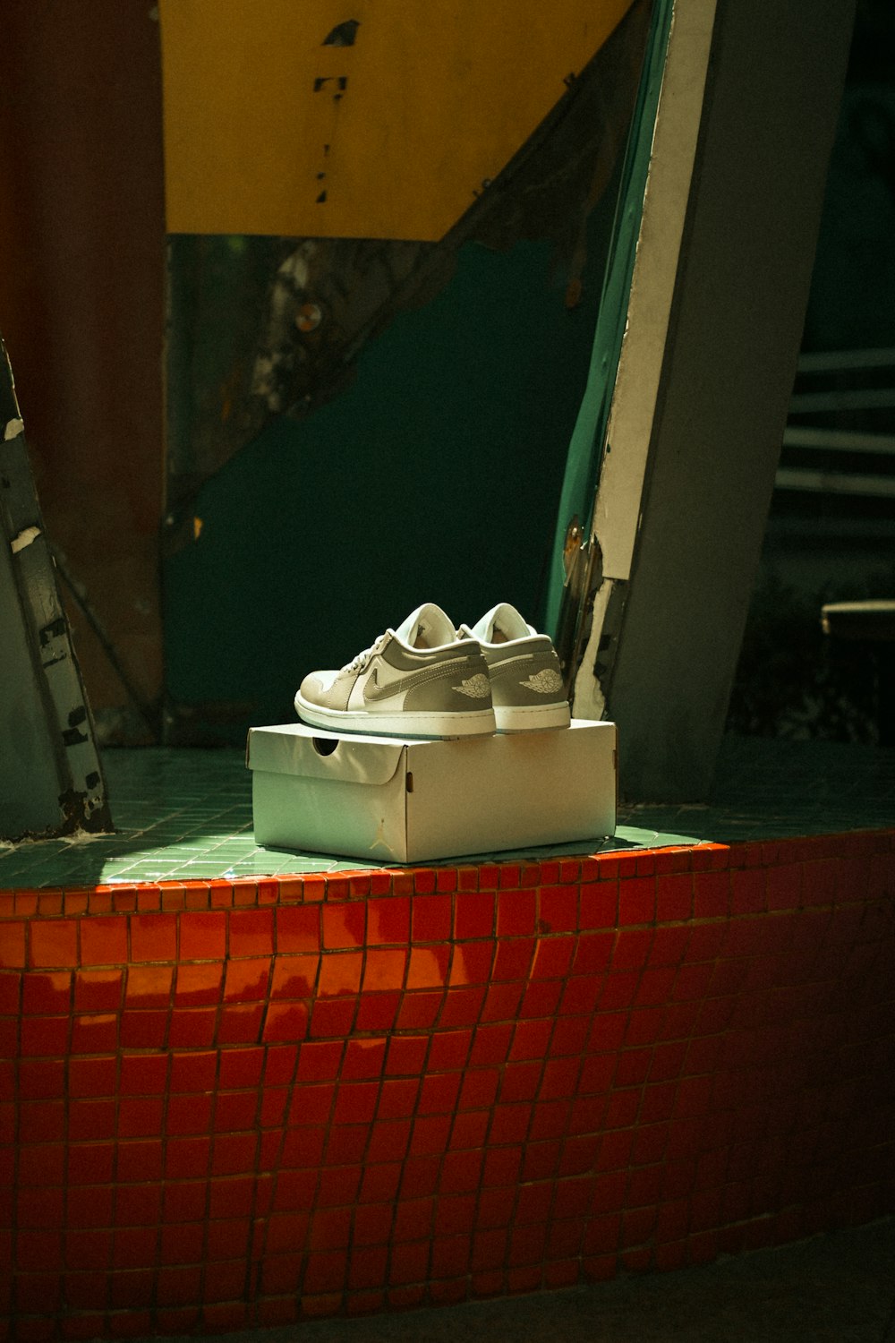 a pair of white shoes sitting on top of a red brick wall