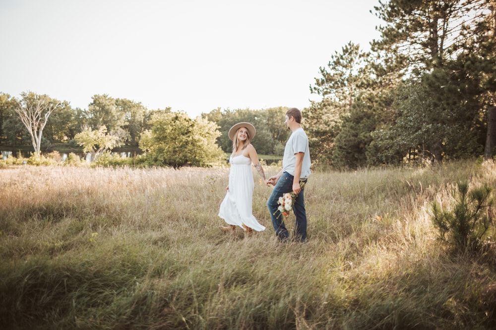 a man and a woman holding hands in a field