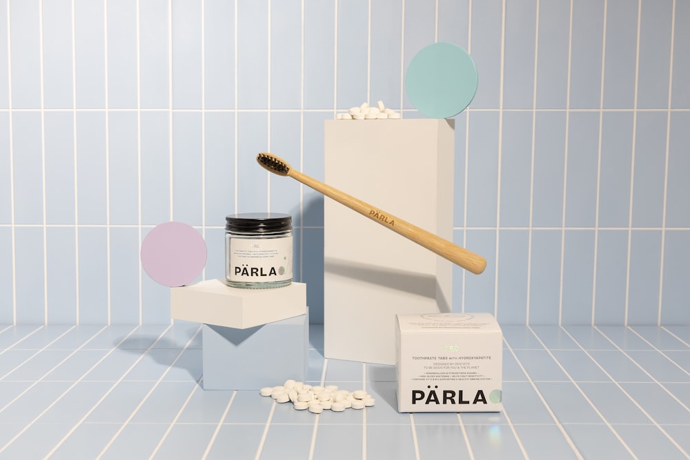 a toothbrush and some pills on a blue tiled floor