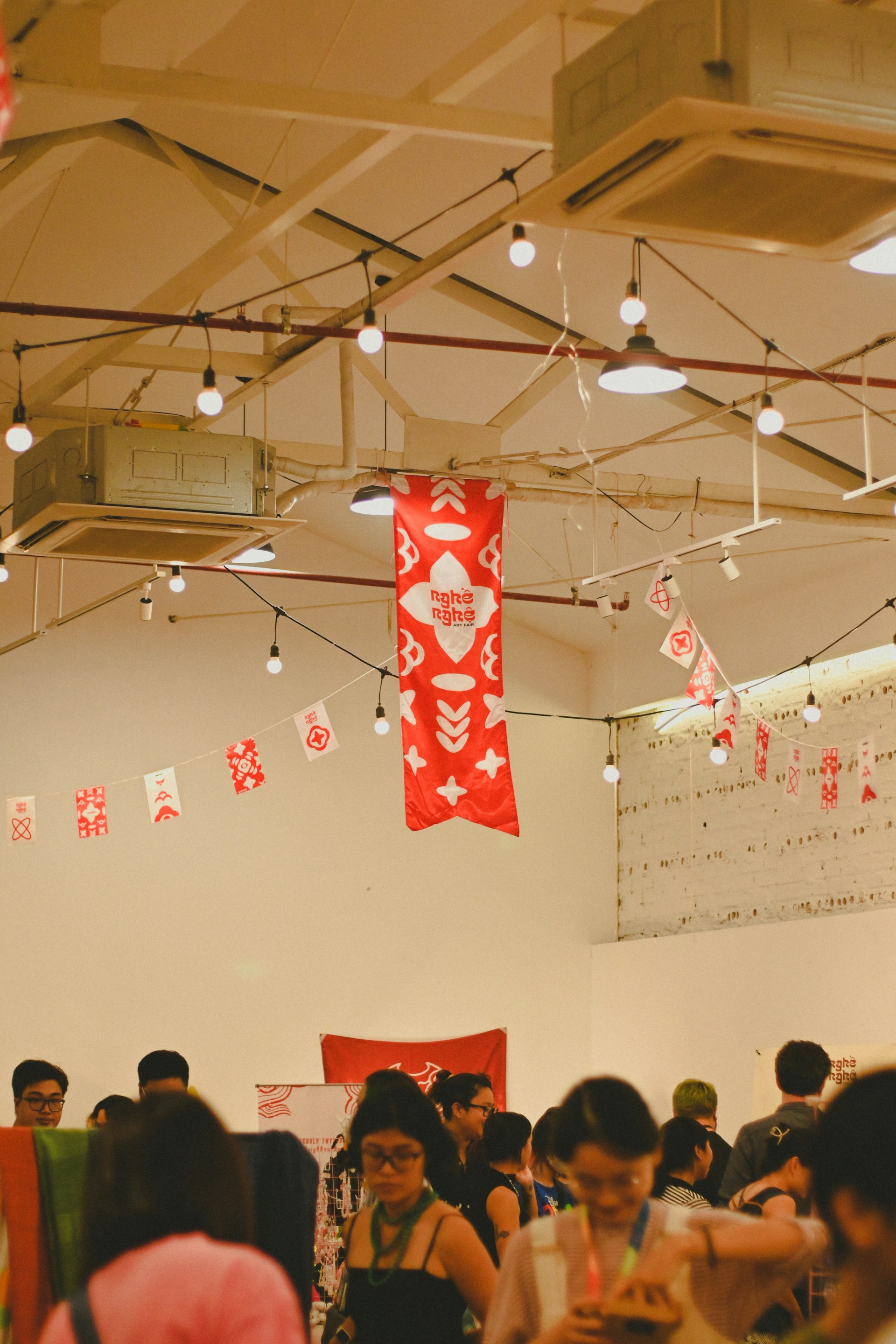 A lively scene of people enjoying the spacio hangar space, blending street food, fashion, and creative industrial elements.