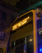 City bus with bright LED advertising screens at sunset