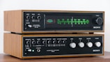 a pair of stereo equipment sitting on top of a wooden table