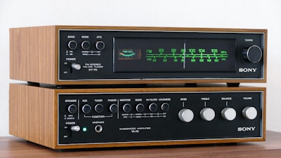 a pair of stereo equipment sitting on top of a wooden table