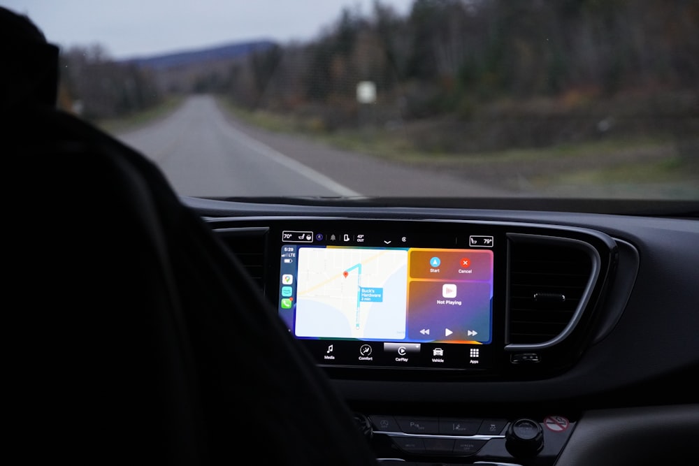 Ein Mann, der ein Auto mit einem GPS-Gerät in der Hand fährt