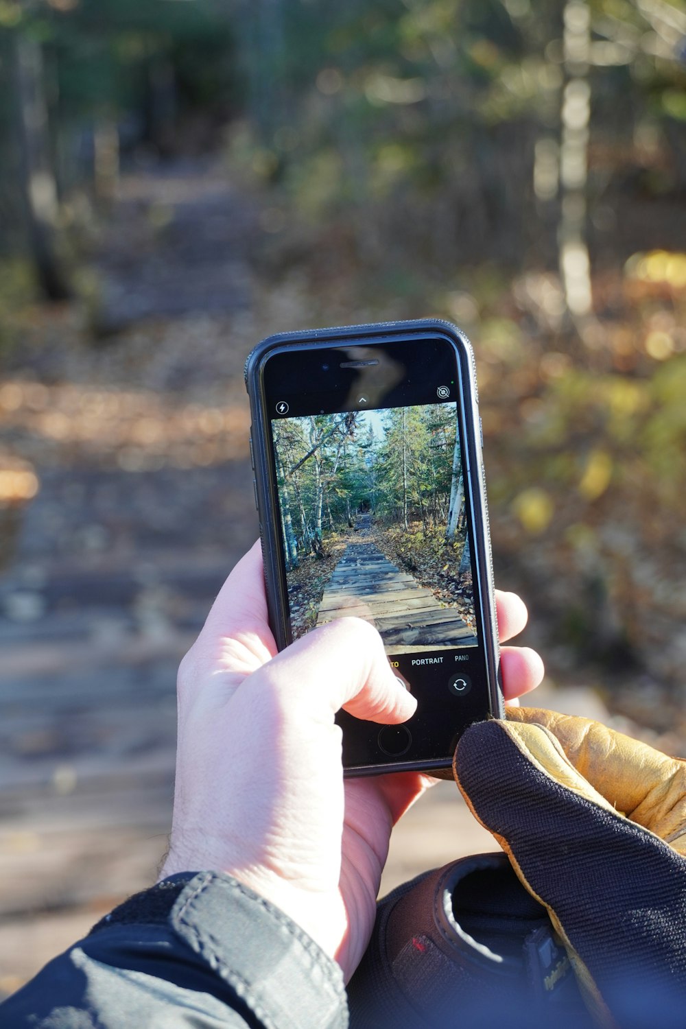 uma pessoa segurando um celular tirando uma foto de uma estrada