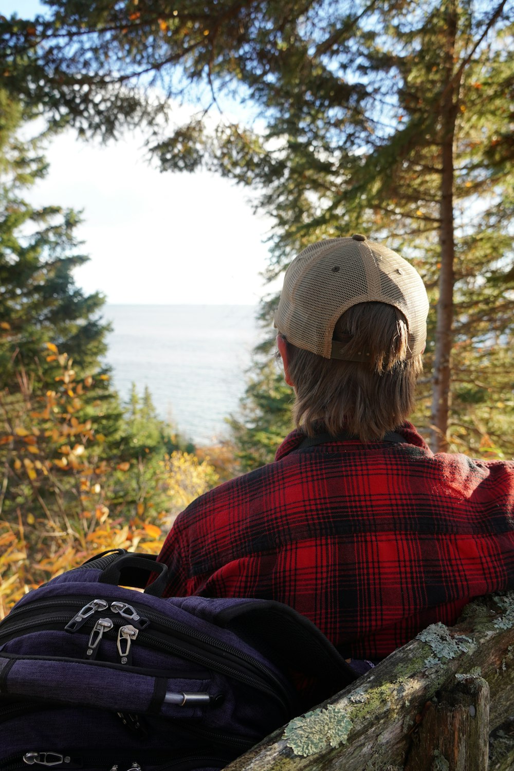 a person sitting on a ledge looking out at the water