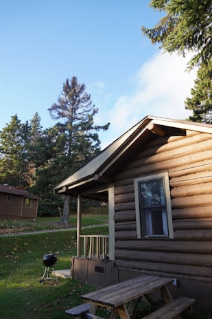a wooden cabin with a picnic table in front of it