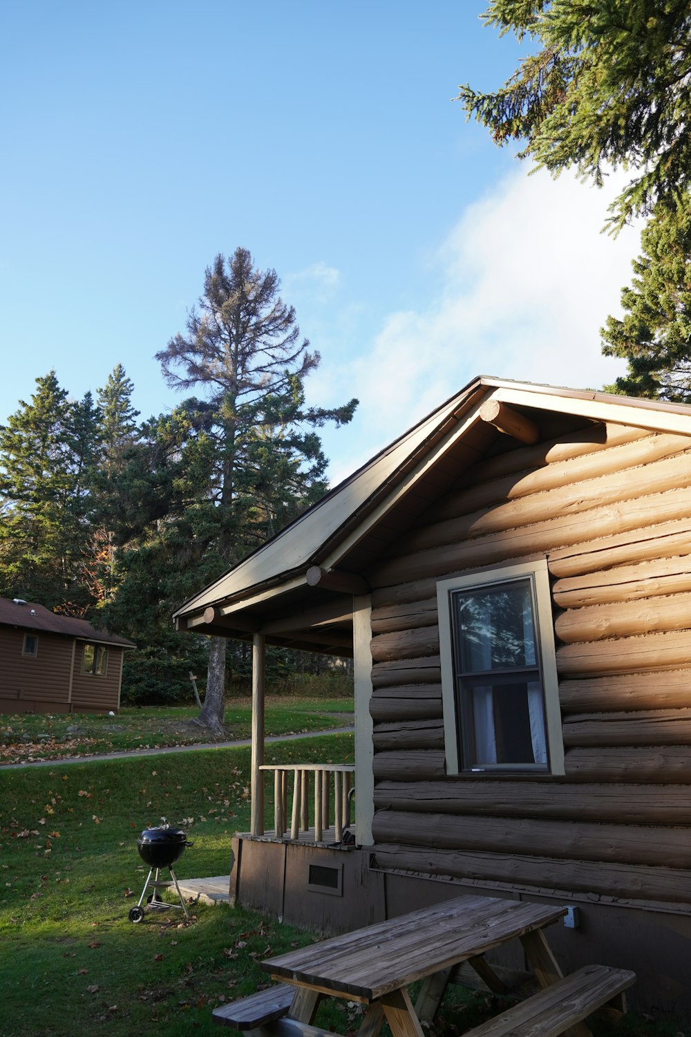 a wooden cabin with a picnic table in front of it