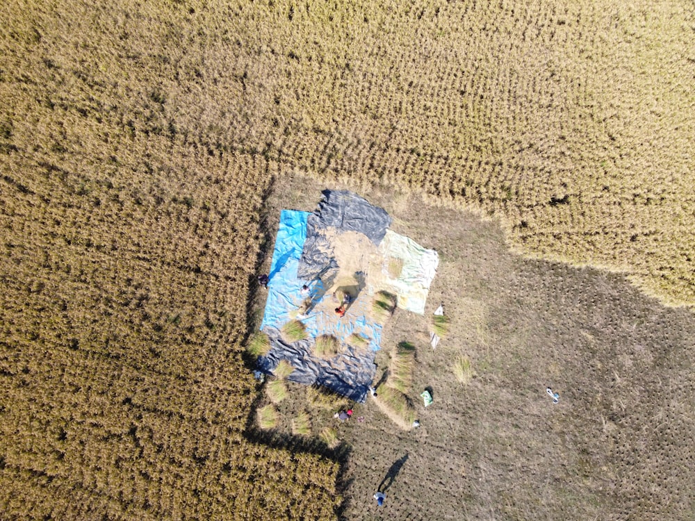 an aerial view of a field with a blue tarp on it