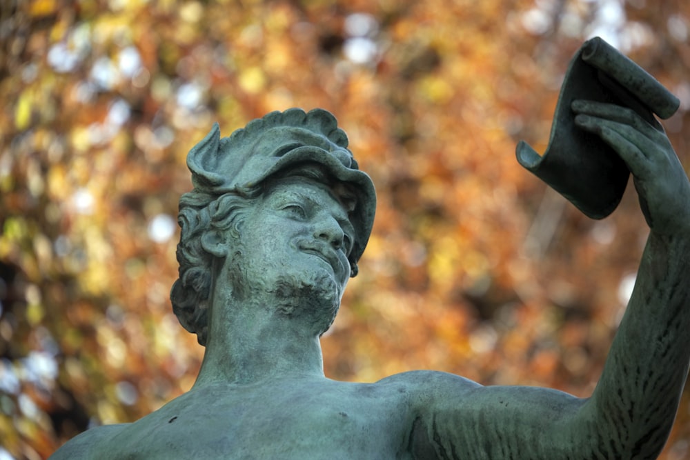 a statue of a man holding a hat
