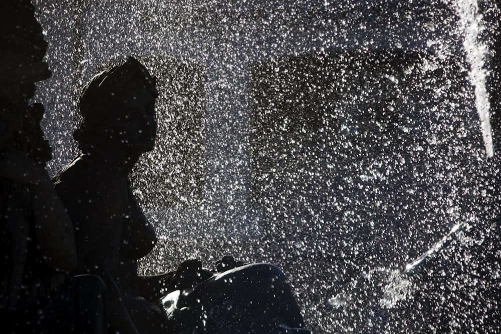 a person standing in the rain with a suitcase