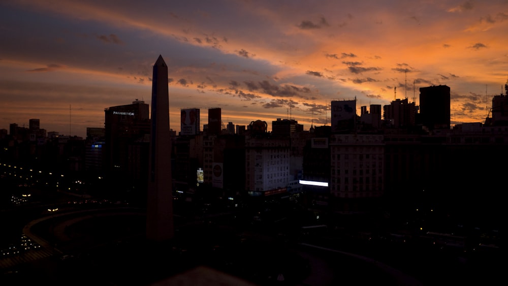 the sun is setting over a city with tall buildings