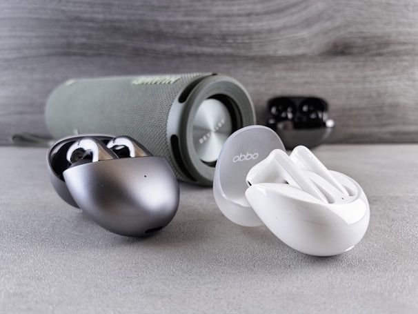 A variety of colorful wireless earbuds and hearables neatly arranged.