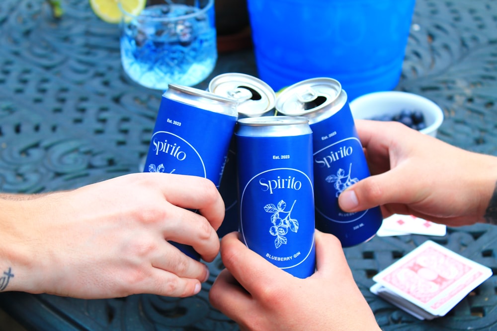 a couple of people that are holding some cans