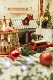 a christmas scene with a toy car and a house