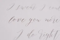 Personalized tumbler with a delicate handwritten name decal on a soft cream background.