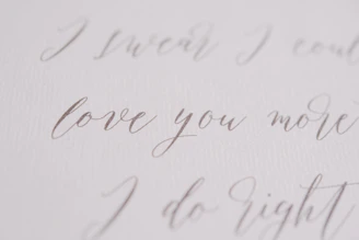 Elegant gold script on navy background reading 'Becoming Loved' surrounded by soft cream accents.