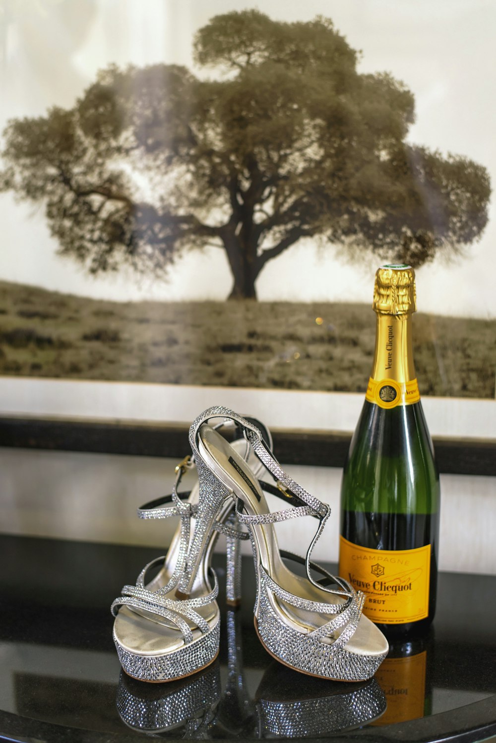 a bottle of champagne and a pair of silver shoes