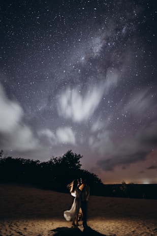 A warm, inviting scene of a couple holding hands under a starlit sky, symbolizing love and reunion.