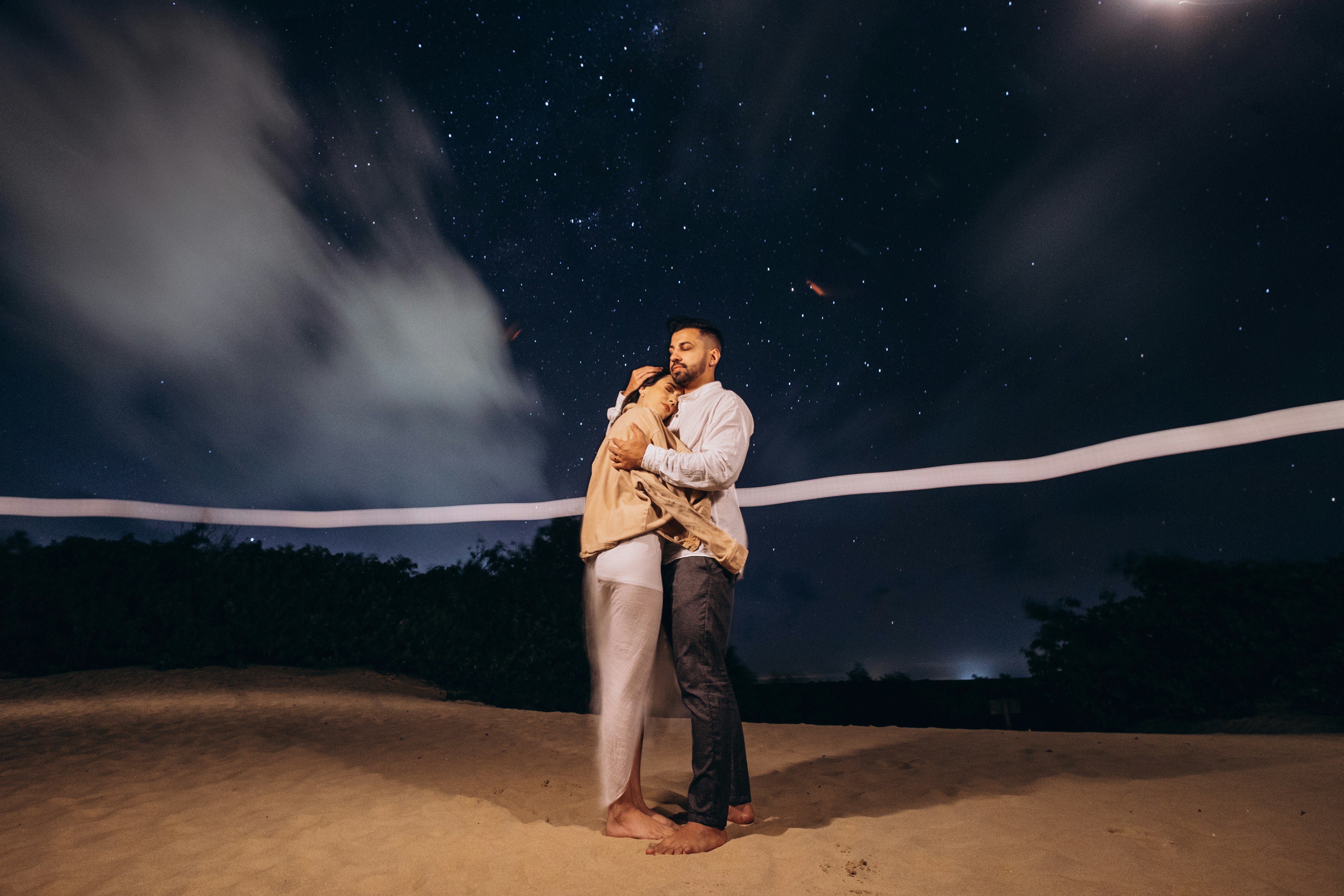 Couple lying together under a starry night sky